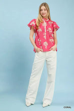 A vibrant coral pink umgee floral ruffle sleeve split neck blouse with ruffled short sleeves and floral pattern