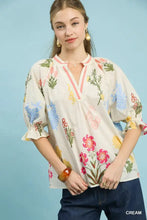 Cream-colored umgee floral split neck puff sleeve blouse with ruffled cuffs and elegant floral print design