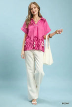 A vibrant pink umgee floral split-neck short sleeve blouse with peony pattern and white embroidery details