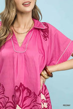 A vibrant pink umgee floral short sleeve kaftan dress with collar and white-trimmed floral split-neck short design