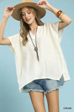 Cream-colored umgee flowy V-neck short sleeve blouse with loose fit and asymmetrical hem perfect for casual wear