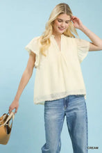 Cream-colored umgee flutter sleeve lightweight blouse with delicate ruffled sleeves and scalloped hemline