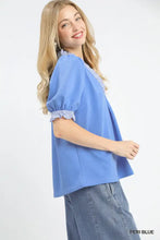 A periwinkle blue french terry blouse with puffed sleeves and ruffle trim collar from umgee french terry ruffle collection