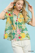 A vibrant green umgee jacquard bloomscape print short-sleeved blouse with collar and rolled cuffs