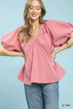 A soft light pink umgee lace inset puff sleeve boho blouse with delicate lace detailing along the neckline