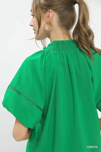 Vibrant green Umgee lace trim peasant top with short sleeves and delicate black lace trim along the cuffs