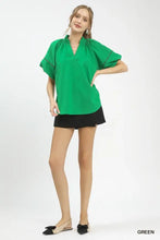 Vibrant green umgee lace trim peasant top with gathered neckline and delicate black lace trim sleeves in short sleeve design