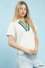 Cream-colored umgee luxe knit v-neck short sleeve polo shirt with green white and purple striped trim