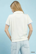 Cream-colored luxe knit short sleeve top with light purple trim on collar and cuffs from Umgee Luxe Knit V-Neck collection