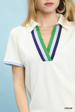 Cream-colored short sleeve luxe knit v-neck blouse with collar and bold green white navy striped trim by Umgee Luxe