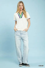 White umgee luxe knit short sleeve top with v-neck accented by purple green and navy stripes