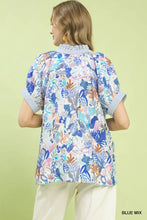 Women’s short-sleeved blue mix boho printed blouse with vibrant botanical leaves flowers and abstract shapes on light background