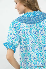 A women’s blue and white ikat mix boho puff sleeve blouse with ruffled cuffs and puff sleeve smocked collar azure mix