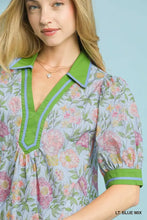 Light blue umgee mix floral puff sleeve blouse with vibrant green collar and cuffs accented by light blue piping