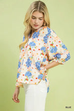 Umgee mixed floral print blouse with short sleeves in blue orange and cream on a light background