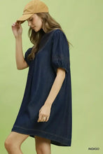 A navy indigo umgee notched puff mini dress with relaxed silhouette and puffed short sleeves made of denim