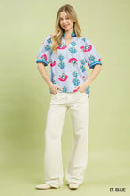 Light blue umgee print puff sleeve blouse with pink teal floral embroidery and contrast trim on short sleeves