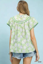 Light green retro floral smocked babydoll blouse with short flutter sleeves and ruffled neckline by umgee retro floral