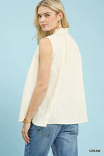 Cream-colored umgee sleeveless textured top with high ruffled neckline and vertical pleats in textured gauze fabric