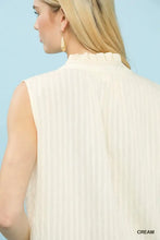 Cream-colored umgee sleeveless textured blouse with vertical pleats and ruffled high neckline in textured gauze fabric