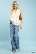 Cream-colored umgee sleeveless textured blouse with soft flowing fabric and subtle pleats at the neckline