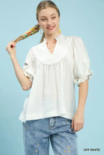 Off-white umgee blouse features smocked yoke with delicate lace trim and ruffle sleeves for elegant style