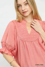 Coral pink umgee smocked yoke blouse with lace trim and ruffle sleeves featuring a smocked neckline collar and cuffs