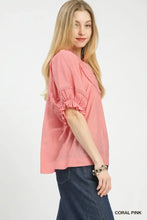 Coral pink umgee smocked yoke blouse with ruffle sleeves and delicate lace trim featuring a smocked yoke design