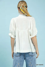 Off-white umgee blouse features smocked yoke and ruffle sleeves with puffed design and ruffled cuffs