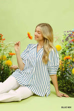 A woman wears an umgee striped puff sleeve blouse in blue and white with loose fit and puffed sleeves