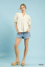 Cream-colored umgee textured blouse with puff sleeves and delicate lace detailing on contrast sleeves