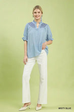 Misty blue umgee textured henley blouse featuring ruffle cuffs and delicate embroidered pattern on lightweight fabric