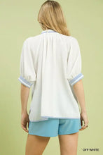 Off-white off-white blouse with textured jacquard fabric and blue-and-white striped jacquard contrast trim at collar and cuffs