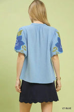 Light blue umgee textured jacquard blouse with jacquard v neck puff sleeves and embroidered floral details in gold and dark blue