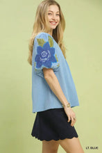 Light blue umgee textured jacquard v neck top with textured jacquard fabric and embroidered floral sleeve design