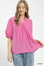 Vibrant pink umgee blouse with textured lace trim, puffed sleeves, and a v-neckline in boho style