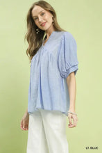 Light blue umgee blouse with puffed sleeves v-neckline and textured lace trim for a boho look