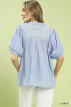 Light blue Umgee blouse with textured lace trim, puffed short sleeves, and gathered bodice in boho style