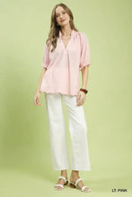 Umgee textured pintuck blouse in light pink featuring a gathered neckline and ruffled cuffs with short sleeves