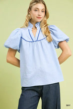 Light blue Umgee textured puff sleeve blouse with puffed short sleeves and navy blue ruffled high neckline trim