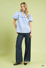 Light blue textured puff sleeve blouse with navy blue trim along the neckline by Umgee textured puff sleeve blouse features
