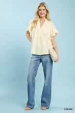 Cream-colored umgee blouse featuring a textured ruffle sleeve design with a subtle textured pattern and flutter sleeves