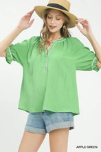 Apple green umgee textured split neck top with ruffled neck puff sleeves and delicate white trim on cuffs and neckline