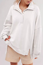 A soft off-white baggy sweatshirt with quarter-zip collar, gold-tone studs, raw detail, machine wash and tumble dry