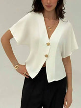 White satin v-neck button-down shirt with neck button and gold-toned circular buttons on wide short sleeves