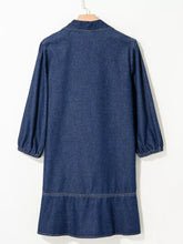 Navy blue long sleeve denim dress with a v neck collar single chest pocket and ruffled hemline