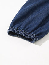 Dark blue denim jogger pant cuff with elasticized hem and stitching paired with v neck collared long sleeve denim dress