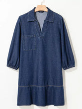 A navy blue long sleeve denim dress with a V neck collar and single chest pocket