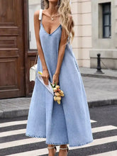 A light blue denim cami dress featuring a v-neckline and thin straps perfect for casual wear