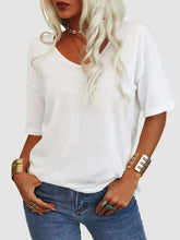 Woman in white V-neck dropped shoulder half sleeve t-shirt and blue jeans